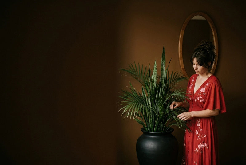 Collection de plantes artificielles au Maroc : femme agençant une composition végétale élégante.
