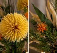Gros plan sur les fleurs jaunes et orange d’une composition florale artificielle, avec feuillage vert et vase doré – Sara Flora