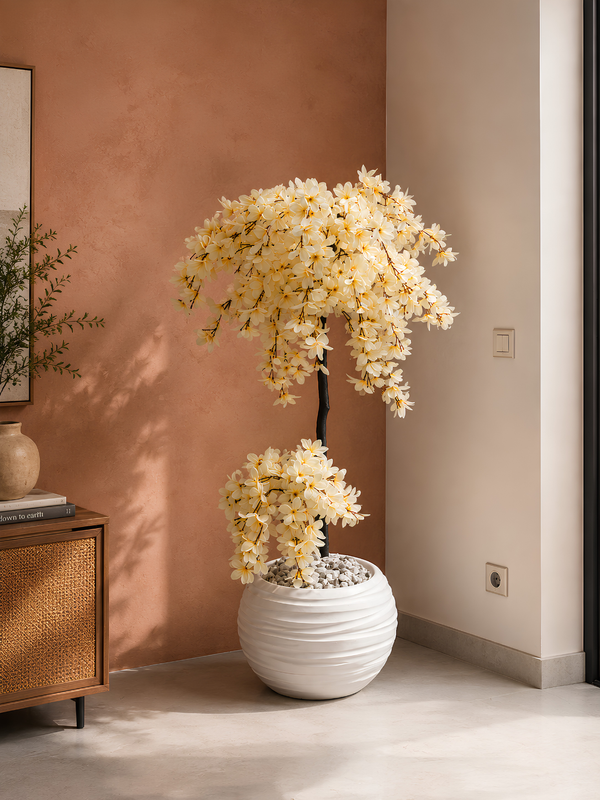 Arbre aux Fleurs de Soie artificiel premium avec fleurs ivoire réalistes dans un pot blanc design, décorant un salon moderne et lumineux au Maroc.