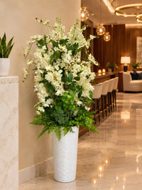 Grand arrangement de fleurs artificielles blanches et jasmin f vase blanc f salon de luxe avec comptoir et éclairage d'ambiance.