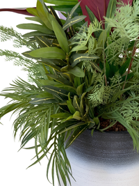 Gros plan sur la base de l'arrangement tropical artificiel et la texture du pot en polyéthylène bicolore