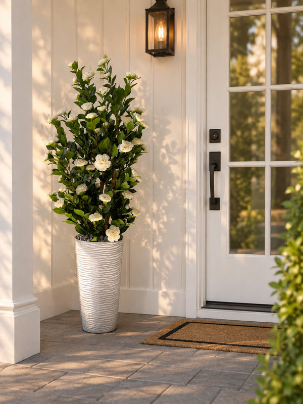 Camélia artificiel 165 cm avec fleurs blanches placé à l'entrée d'une maison moderne sur terrasse