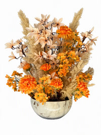 Vue studio sur fond blanc de la fleur artificielle Soleil d'Automne aux teintes orange, pêche et pampa dans un vase bas en porcelaine effet marbre