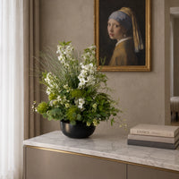 Fleur artificielle Symphonie de Névada de 60 cm posée sur un meuble en marbre dans un salon chic avec tableau de style classique