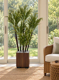 Plante artificielle Dracaena Fleuri haut de gamme hauteur 145 cm mise en situation dans un salon lumineux près d'une baie vitrée dans un bac en bois noyer SaraFlora
